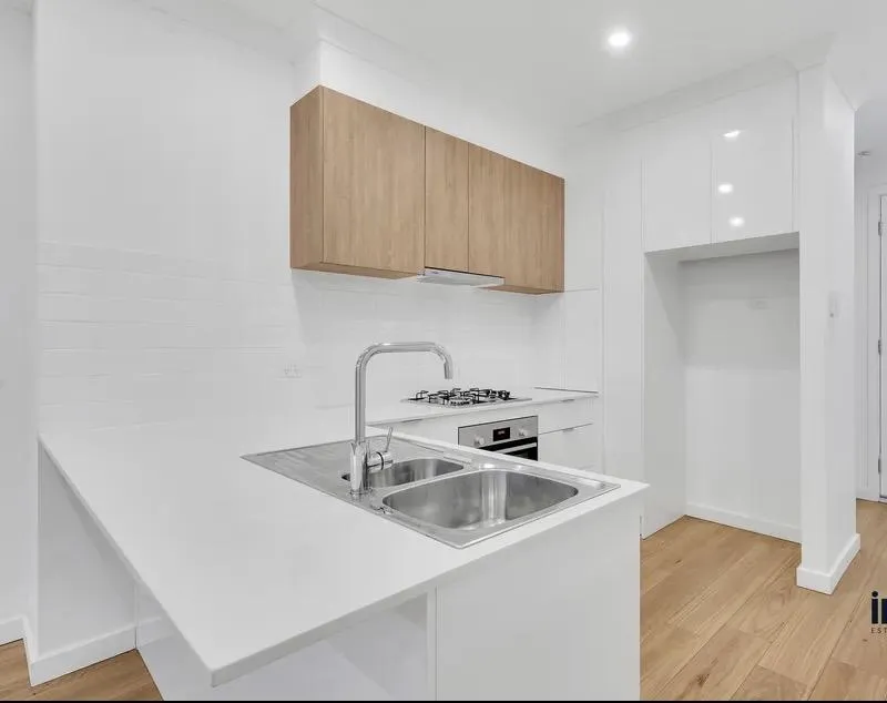 A finished white kitchen with timber overhead cabinets
